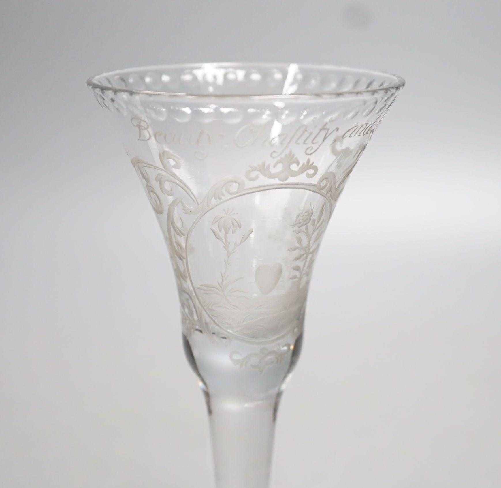 A Georgian wine glass, possibly later engraved ‘Beauty, Chastity, and Love above a lily, heart and rose. 16cm